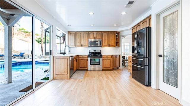 kitchen with stainless steel appliances, light hardwood / wood-style floors, and sink