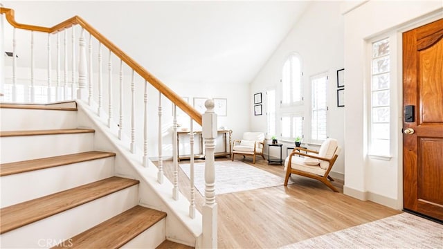 foyer entrance with vaulted ceiling and light hardwood / wood-style floors