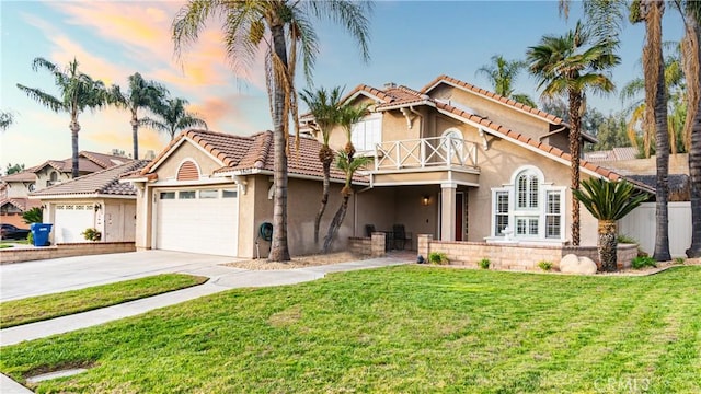 mediterranean / spanish-style home with a lawn, a balcony, and a garage