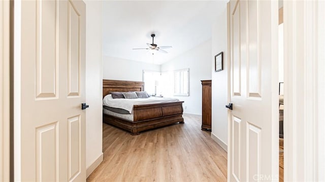 bedroom with vaulted ceiling, light wood-type flooring, and ceiling fan