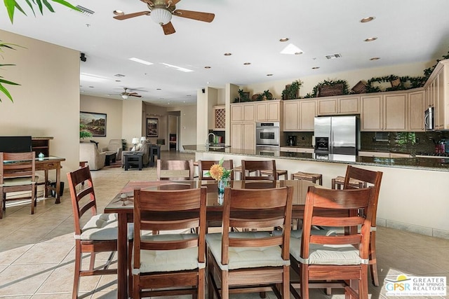 dining area with ceiling fan, light tile patterned floors, and sink