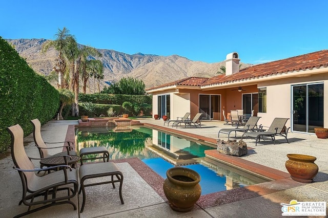 view of pool with ceiling fan, a mountain view, a jacuzzi, and a patio