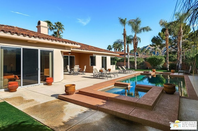 back of house with a pool with hot tub and a patio