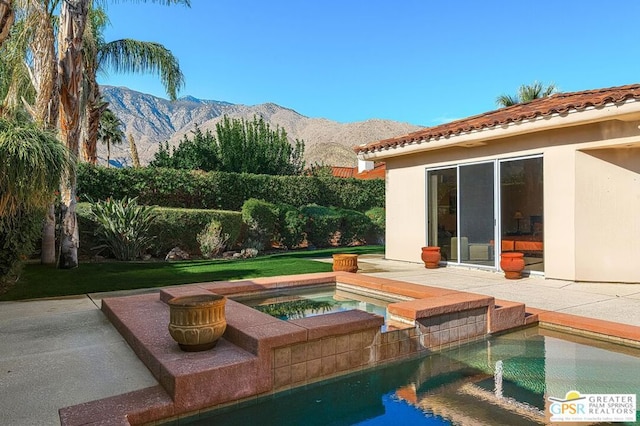 view of pool featuring an in ground hot tub, a yard, and a mountain view