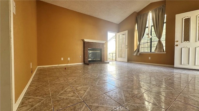 unfurnished living room with a brick fireplace, a textured ceiling, and vaulted ceiling