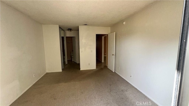 unfurnished bedroom featuring a textured ceiling and carpet flooring