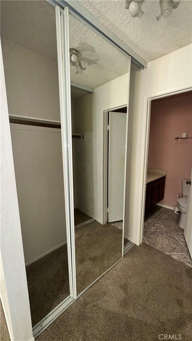 interior space featuring toilet and a textured ceiling