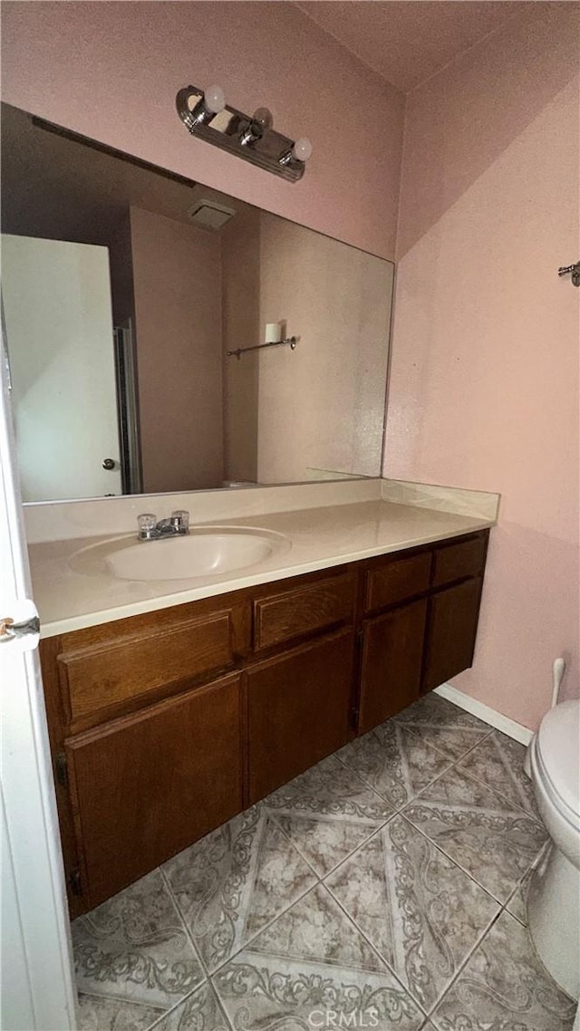 bathroom featuring toilet, tile patterned flooring, and vanity