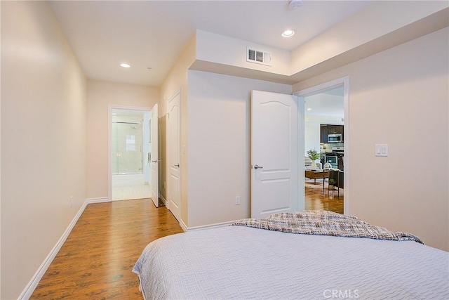 bedroom featuring hardwood / wood-style floors and ensuite bath