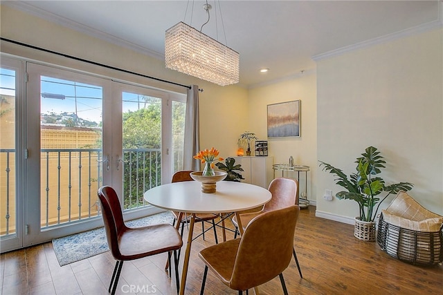 dining room featuring wood-type flooring, a notable chandelier, ornamental molding, and french doors