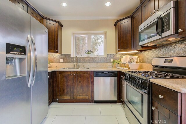 kitchen featuring stainless steel appliances, ornamental molding, dark brown cabinetry, and sink