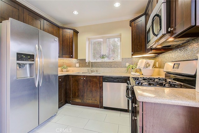 kitchen with appliances with stainless steel finishes, decorative backsplash, sink, light stone counters, and crown molding