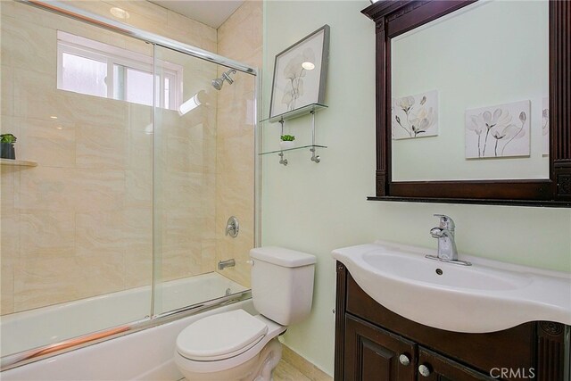 full bathroom with toilet, vanity, and shower / bath combination with glass door