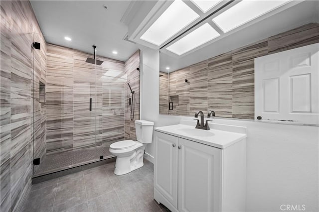 bathroom with vanity, toilet, tile patterned floors, and walk in shower