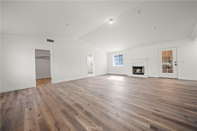 unfurnished living room featuring light wood-type flooring and lofted ceiling