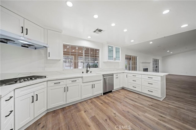 kitchen with white cabinets, appliances with stainless steel finishes, sink, and light hardwood / wood-style floors