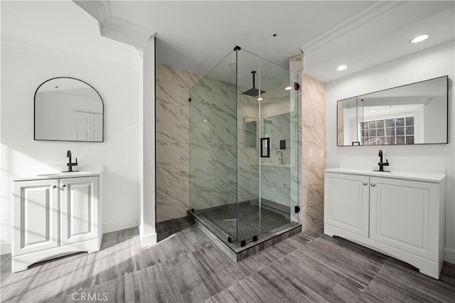 bathroom with a shower with shower door, vanity, and crown molding