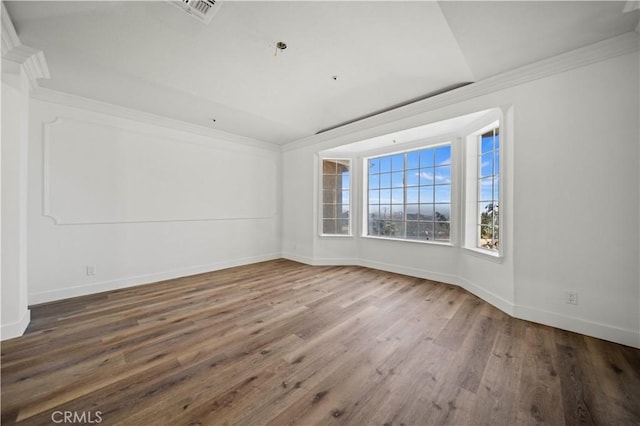 spare room featuring crown molding and hardwood / wood-style flooring