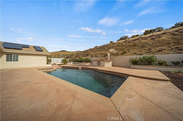 view of pool with a mountain view and a patio