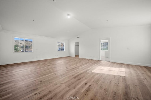 spare room with lofted ceiling and light hardwood / wood-style floors