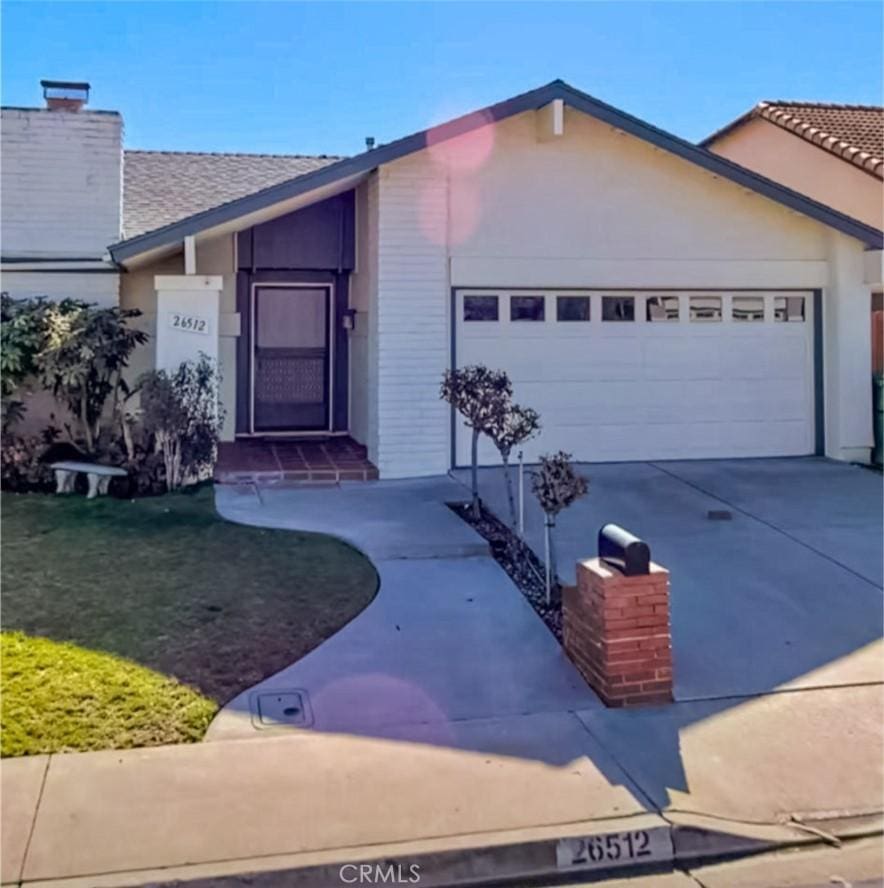 single story home featuring a front lawn and a garage