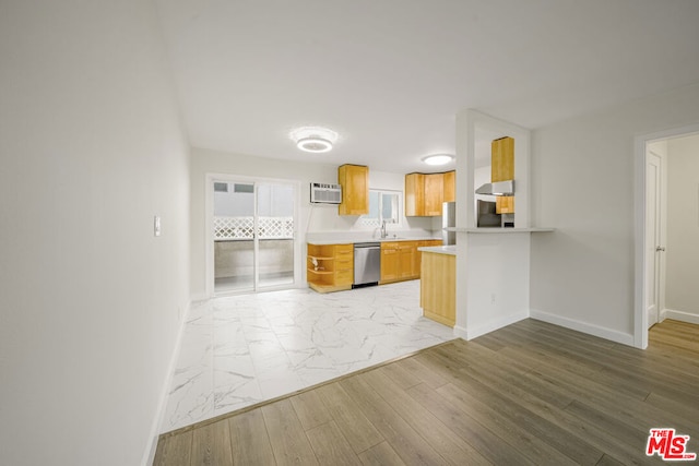 kitchen featuring kitchen peninsula, light brown cabinets, stainless steel dishwasher, light hardwood / wood-style flooring, and an AC wall unit