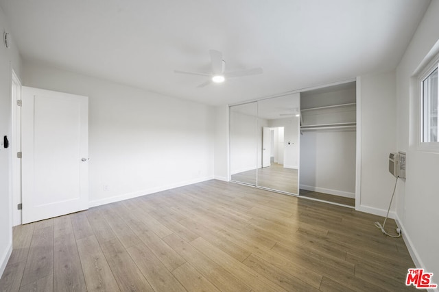 unfurnished bedroom with ceiling fan, a closet, and hardwood / wood-style floors