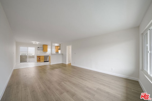 unfurnished living room featuring plenty of natural light and light hardwood / wood-style flooring