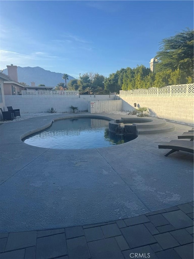 view of swimming pool with a mountain view and a patio