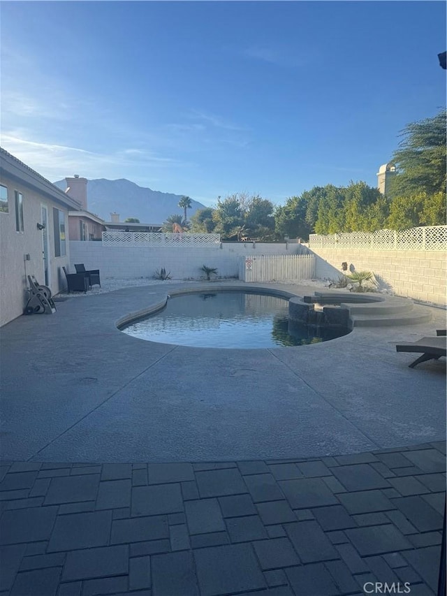 view of pool with a mountain view and a patio