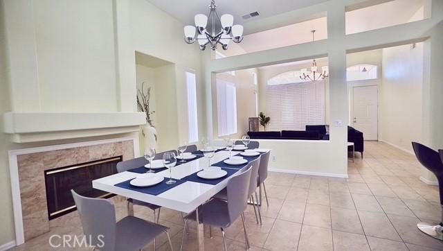 dining space with a notable chandelier, a premium fireplace, and light tile patterned flooring