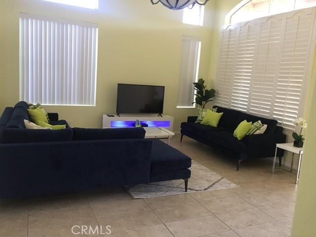 tiled living room with a notable chandelier