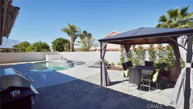 view of swimming pool with a mountain view, a patio area, and a gazebo