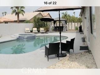 view of swimming pool featuring an in ground hot tub and a patio area