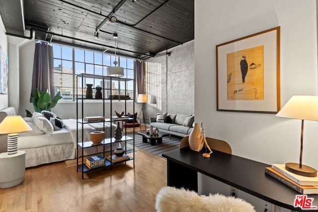 bedroom with a wall of windows and hardwood / wood-style floors