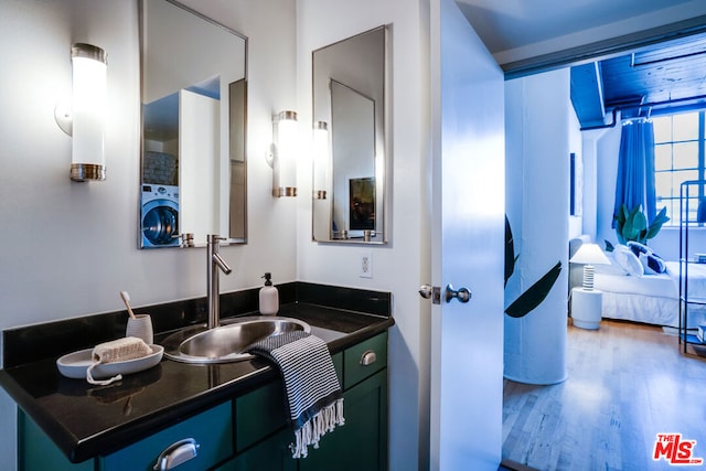 bathroom featuring hardwood / wood-style flooring, washer / dryer, and vanity