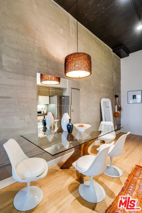 dining space featuring a towering ceiling and hardwood / wood-style flooring