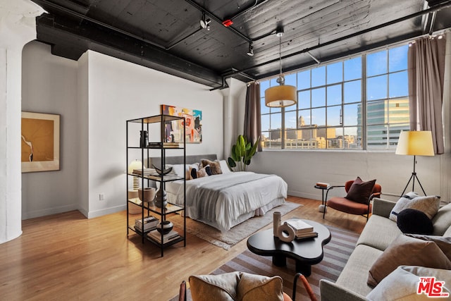 bedroom with light hardwood / wood-style floors and rail lighting