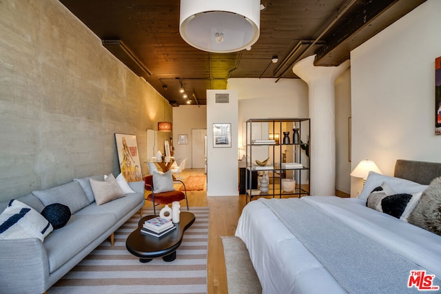 bedroom featuring hardwood / wood-style flooring and rail lighting