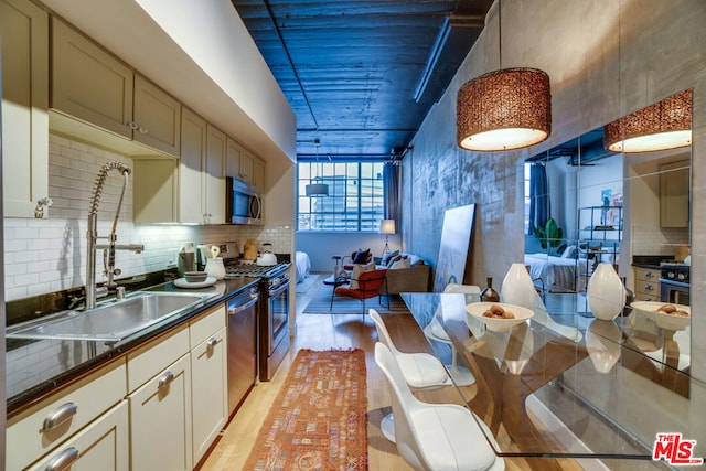 kitchen featuring light hardwood / wood-style floors, sink, decorative backsplash, and appliances with stainless steel finishes