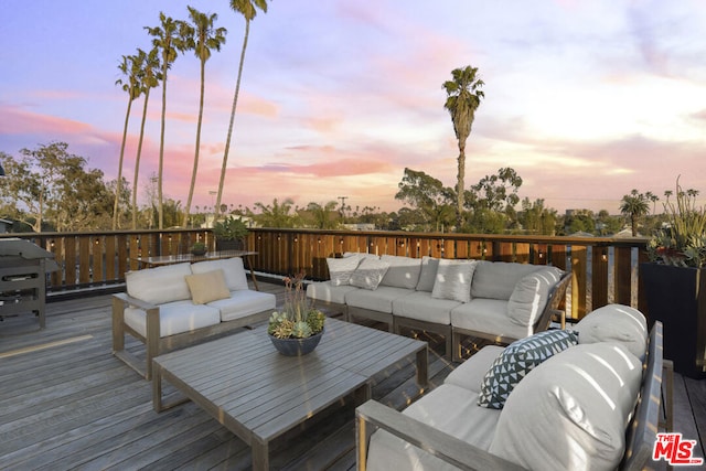 deck at dusk with an outdoor hangout area