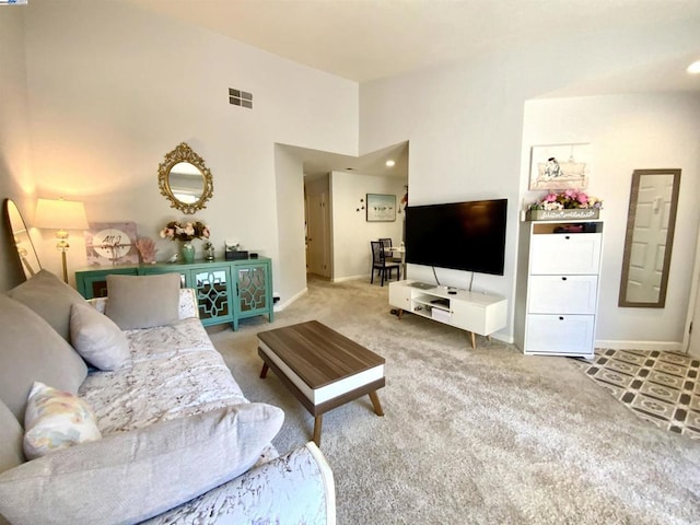 living room featuring a towering ceiling and carpet floors