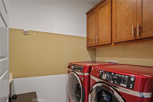 laundry room with washer and dryer and cabinets