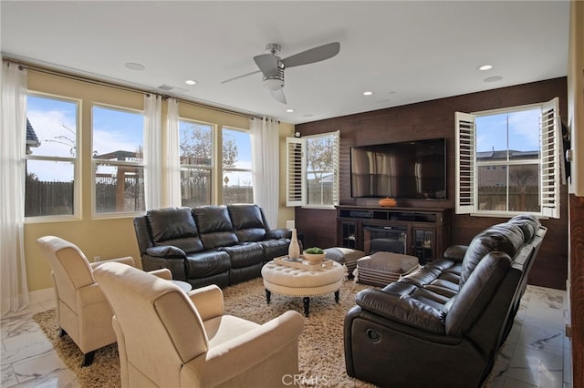 living room with ceiling fan and a high end fireplace