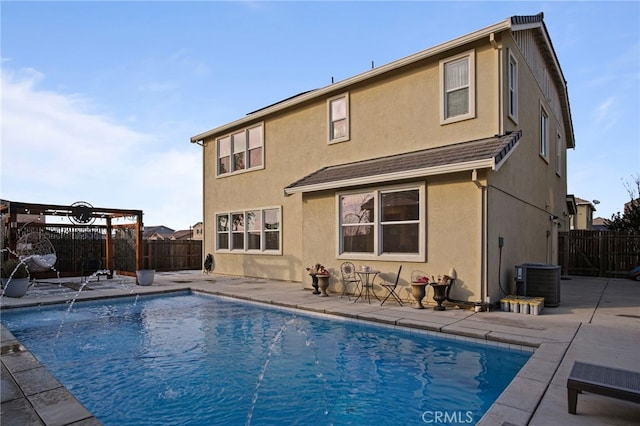 back of property featuring a patio area, cooling unit, pool water feature, and a fenced in pool