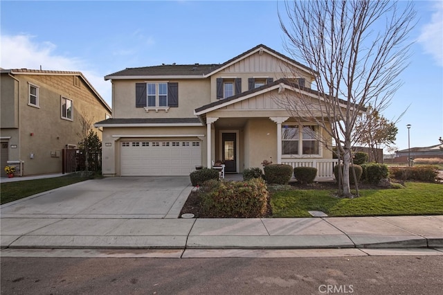 view of front of property with a garage, a front yard, and covered porch