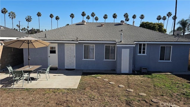 back of house with a patio area and a lawn