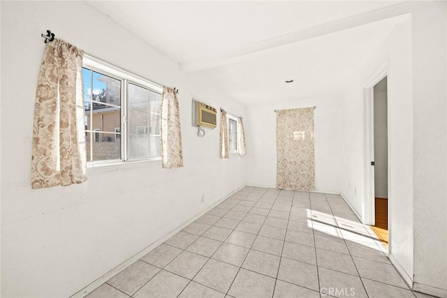 tiled spare room featuring beam ceiling and a wall mounted AC