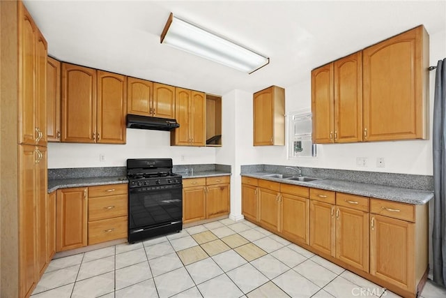 kitchen featuring black gas range oven, light tile patterned floors, and sink