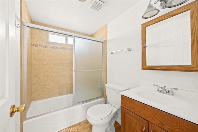 full bathroom with toilet, vanity, tile patterned flooring, and bath / shower combo with glass door